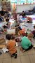 dzieci pracują na dywanie oklejajac pudła