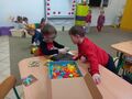 Dwaj chłopcy z grupy Słoneczka układają obrazek z figur geometrycznych