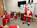 Dzieci z grupy Gwiazdeczek śpiewają piosenkę. Święty Mikołaj siedzi na krześle i przygląda się dzieciom