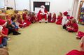 Dzieci z grupy Promyczki siedząc w kole rozmawiają ze Świętym Mikołajem