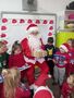 Dzieci z grupy Słoneczka wreczają Mikołajowi prezent