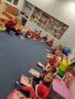 Dzieci z grupy kropelki siedzą na dywanie z prezentami