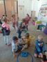 Dzieci z grupy Słoneczka segregują na dywanie piłki według kolorów