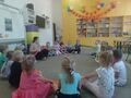 Dzieci z grupy Słoneczka bawią się na dywanie kolorową gumą sensroyczną