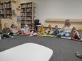 Dzieci siedzace na dywanie z nauczycielem