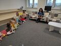 Pania Maryla czyta dzieciom siedzacym na dywanie ksiazke