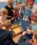 Dzieci wspólnie ustawiają szablony mebli w papierowym domu