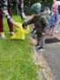 Chłopiec z Grupy Gwiazdeczek wrzuca znaleziony papierek do worka na śmieci