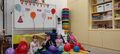 Troje dzieci w przebraniach siedzi wsrog balonow