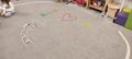 Obrazek na dywanie ułożony z kolorowych patyczków w tle jedna dziewczynka