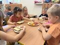 Dzieci układają ser i wędlinę na chlebie