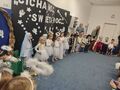 Dzieci w roli aniołów królów pasterzy i Maryi stojących na dywanie na zakończenie przedstawienia