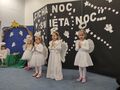 Dziewczynki w roli aniołów śpiewają stojac na dywanie