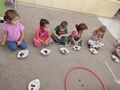 Piatka dzieci prezentuje swoje kasztany i zoledzie w miseczkach