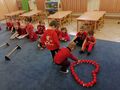 Przedszkolaki pokonują tor przeszkód i wyklejają piłkami serce