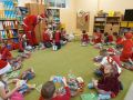 Dzieci z grupy Chmurki w swojej sali w towarzystwie Mikolaja rozpakowuja swoje prezenty