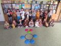 Dzieci z grupy Promyczki prezentujace maski oraz misia z kolek na dywanie