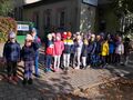 Przedszkolaki stoją przed budynkiem banku