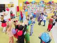 Przedszkolaki tańczą w parach z kolorowymi balonami