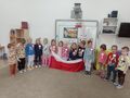 Dzieci trzymają flagę Polski i śpiewają hymn