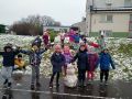 19 dzieci z grupu Promyczkow stoi na gorce prezentujace ulepionego balwanajpg