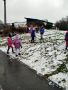Chlopcy i dziewczynki stoja na gorce i lepia kulki ze sniegujpg