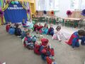 Dzieci siedzą na dywanie w dwóch rzędach