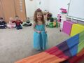 Dziewczynka na tle innych dzieci prezentuje swój strój księżniczki Elzy