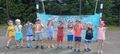 Grupa dzieci prezentuje pomalowane dłonie i obraz namalowany śmietaną na folii