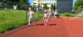 Dwie dziewczynki w strojach sportowych biegną po bieżni