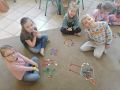 Dzieci prezentuja symbole wiosny ulozone z darow Froebla