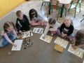 Przedszkolaki ukladaja szlaczki z makaronu