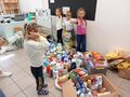 Dzieci z przedszkola pomagają pakować zebrane dary