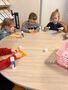 Dzieci siedzą przy stole i wykonują pracę plastyczną