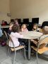 Dzieci z grupy Gwiazdeczkek w czytelni siedzą przy stole