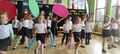 8. Grupa dzieci tańcząćych z szarfami kolami hula hop i na klawesach